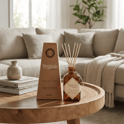 Reed diffuser and packaging on a wooden table in a living room setting