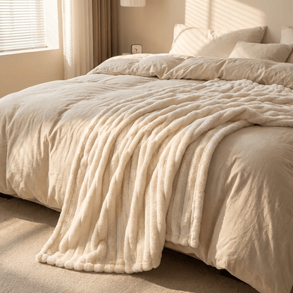 Ribbed fleece throw blanket on a bed in a bedroom